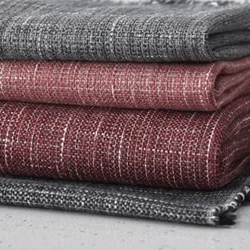 Stack of textured upholstery fabric swatches in deep grey and red tones, showcasing sturdy weaves perfect for reupholstering chairs or sofas with a modern touch