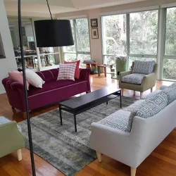 Modern living room with reupholstered sofas and armchairs in rich jewel tones and patterned fabrics, blending comfort with a fresh, stylish update